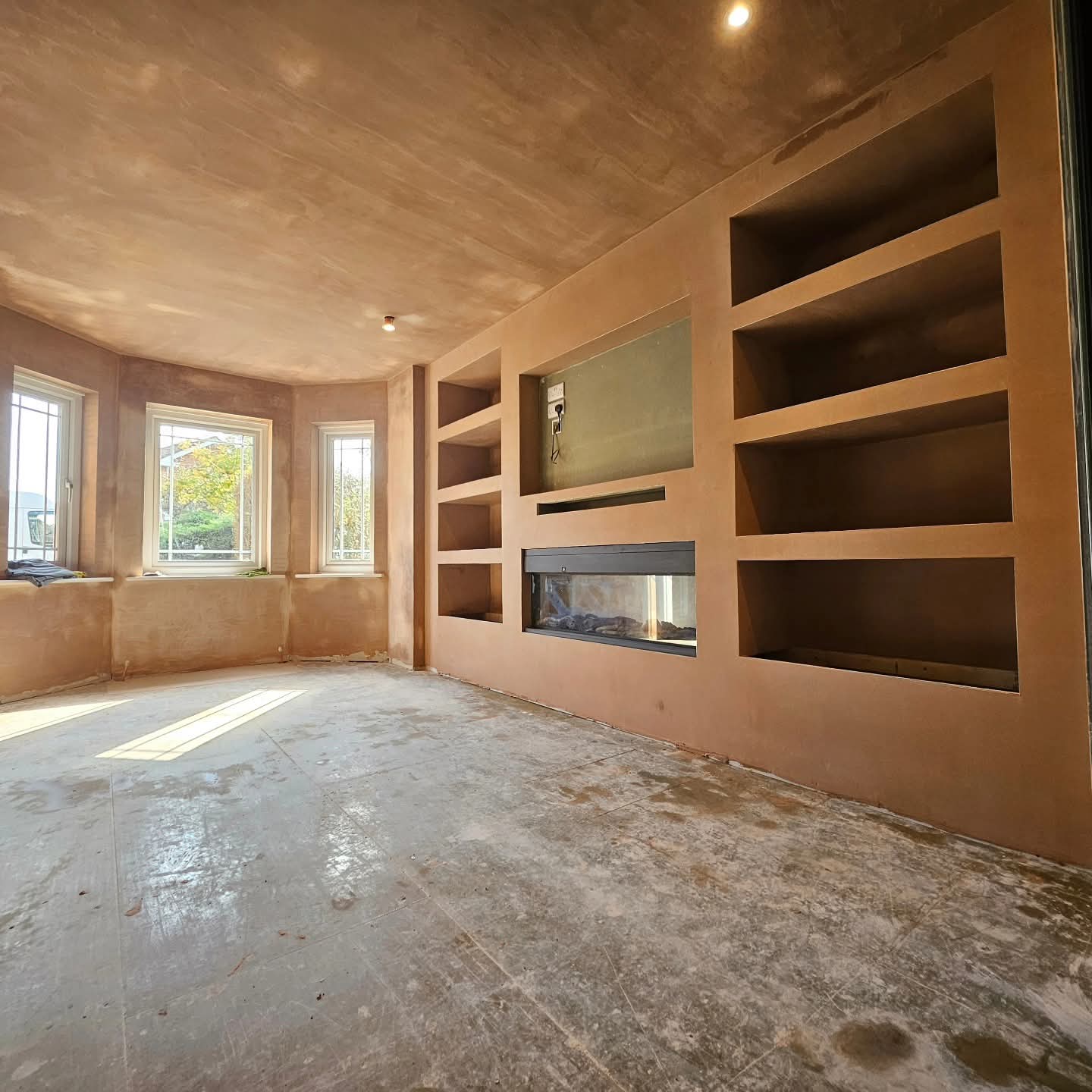 Media wall with built-in shelving skimmed ready for paint